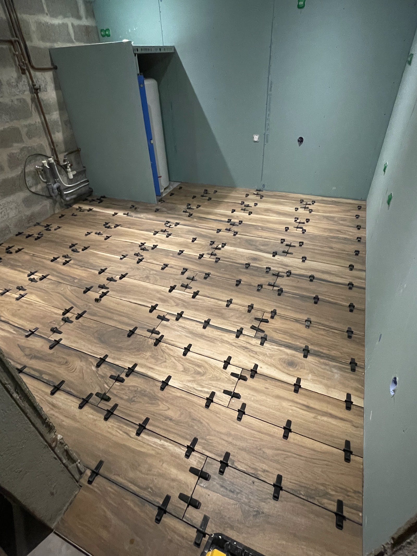 Installation d'un sol aspect bois chaleureux dans une pièce technique.